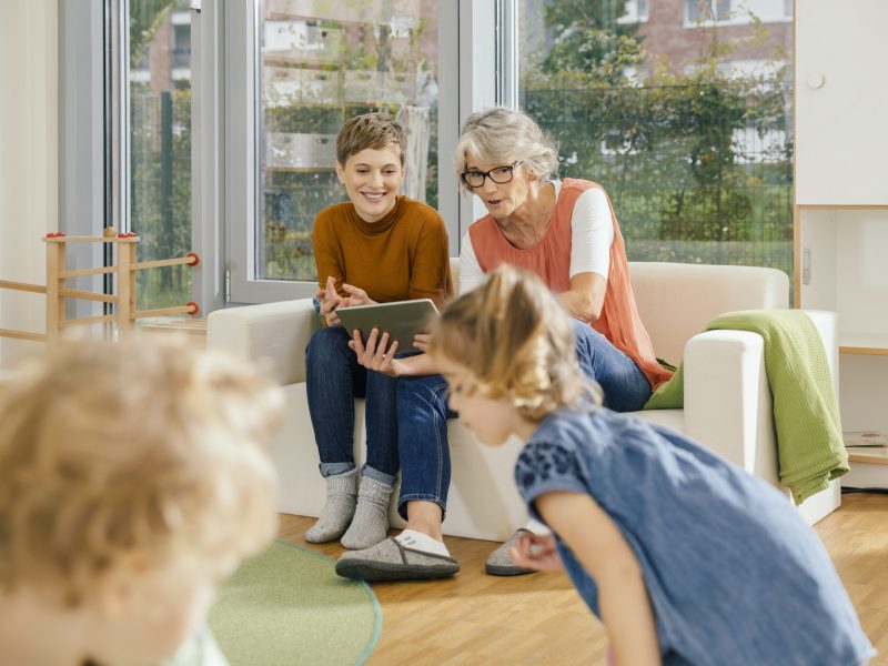 pre-school-teachers-with-tablet-looking-at-children-in-kindergarten.jpg